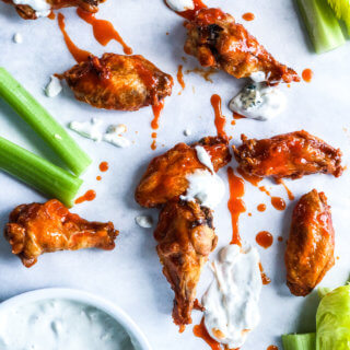 Chicken wings with buffalo sauce and celery sticks with blue cheese sauce