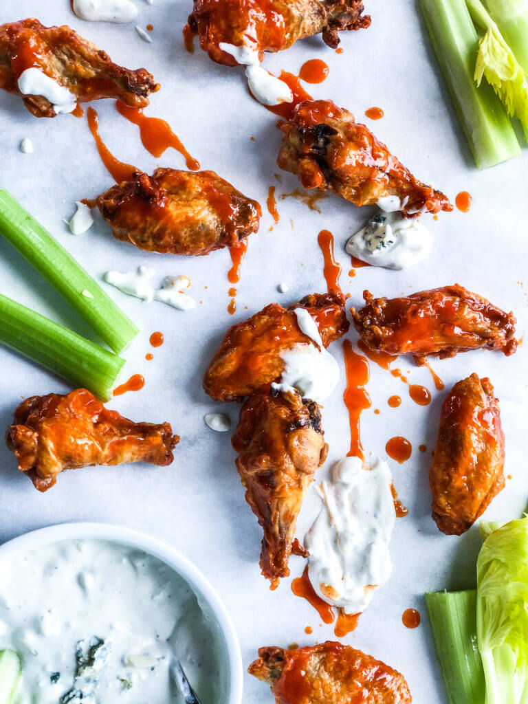 Chicken wings with buffalo sauce and celery sticks with blue cheese sauce