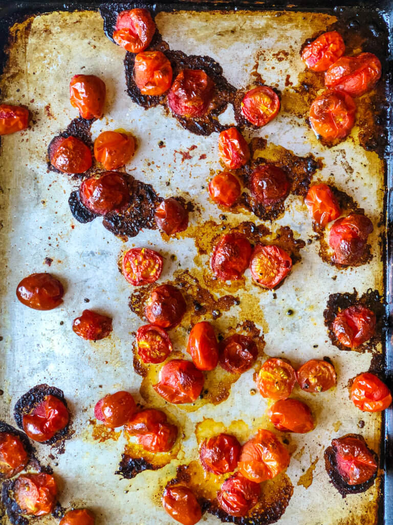 Roasted tomatoes on baking sheet process shot