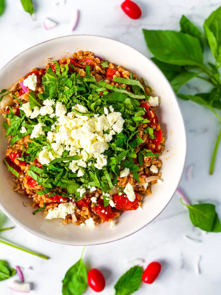 Farro Salad with roasted tomatoes, red onions and a pile of shredded mint and basil all topped with crumbled feta cheese - featured image
