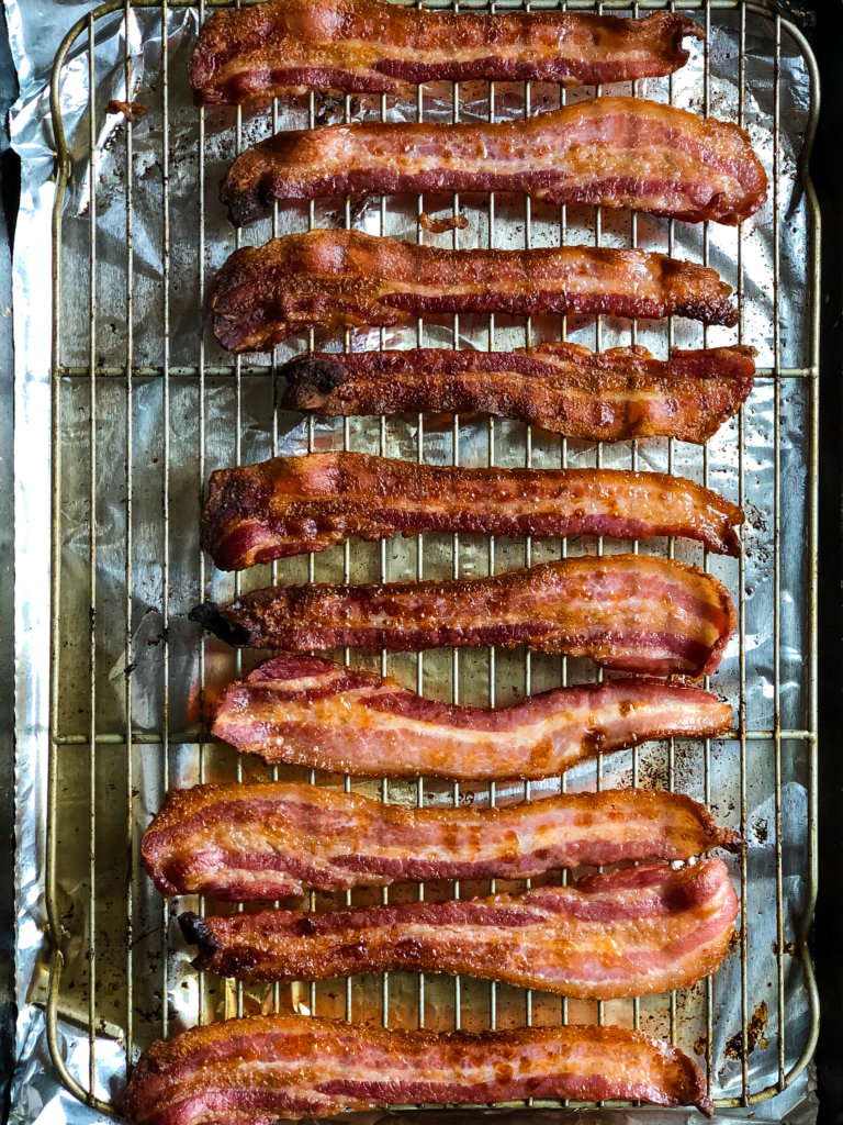 Shows bacon cooked crispy over a grate set on sheet pan