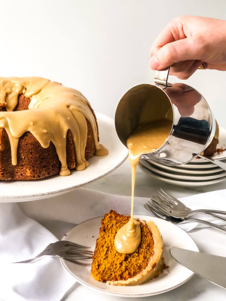 Shows caramel frosting being poured slowly over slice of pumpkin bundt cake