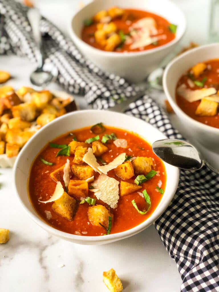 Featured Image Shows overhead 45-degree view of 3 bowls of soup and a bowl of croutons, spoon resting on front bowl