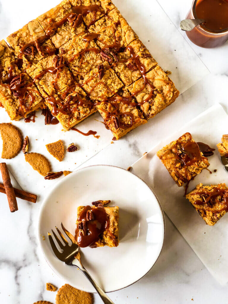 Overhead shot showing serving suggestions for Sweet Potato Cheesecake Bars, including caramel sauce on top, chopped nuts