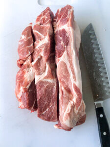 Process Shot for Pulled Pork BBQ shows sliced pork shoulder