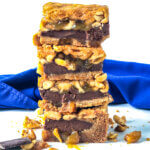 Stack of 4 Black-Bottom Peanut Pie bars with layer of ganache, peanuts and cookie crust.