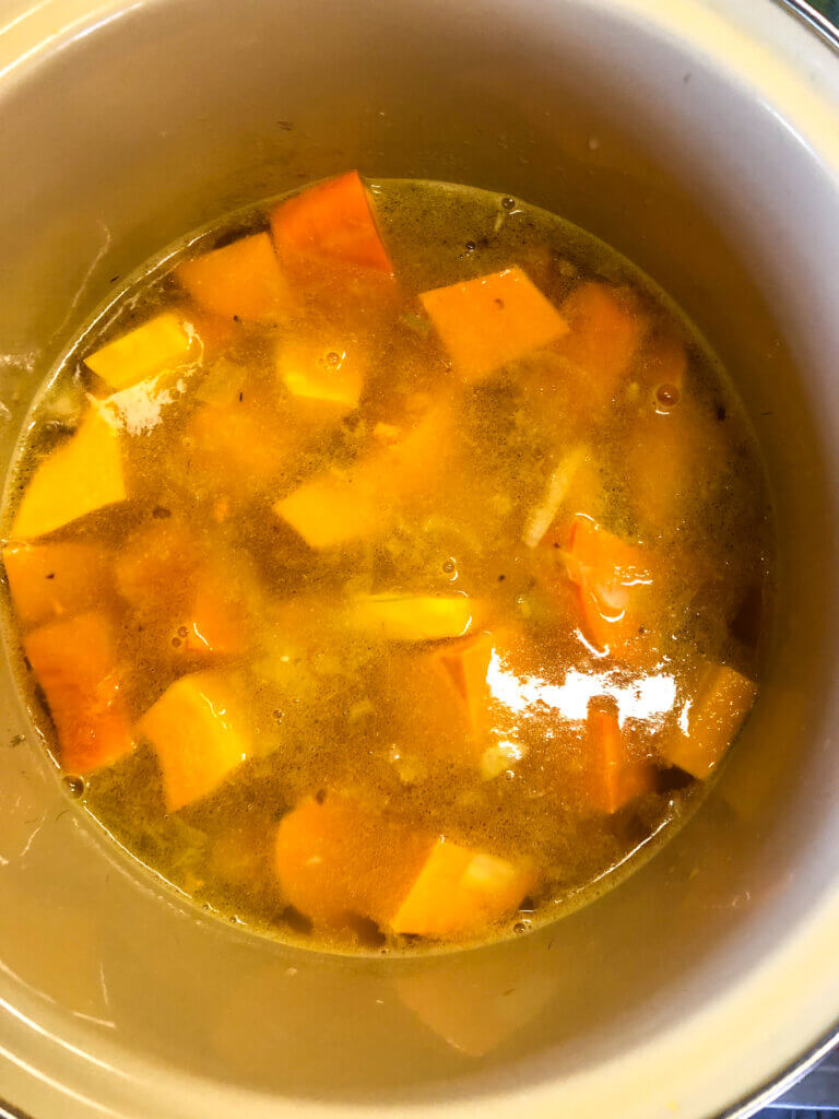 Process shot Shows sweet potatoes and squash added to the stock mixture