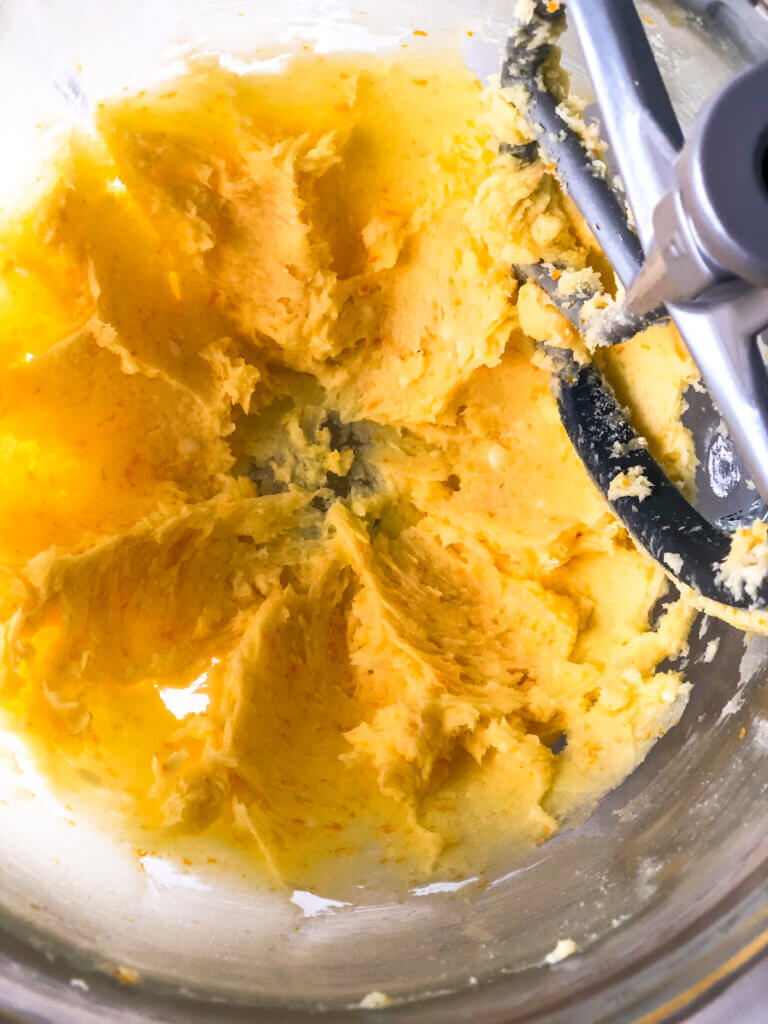 How to make shortbread cookies process shot showing Overhead view of creamed butter, sugar, salt, orange zest, almond extract in mixing bowl