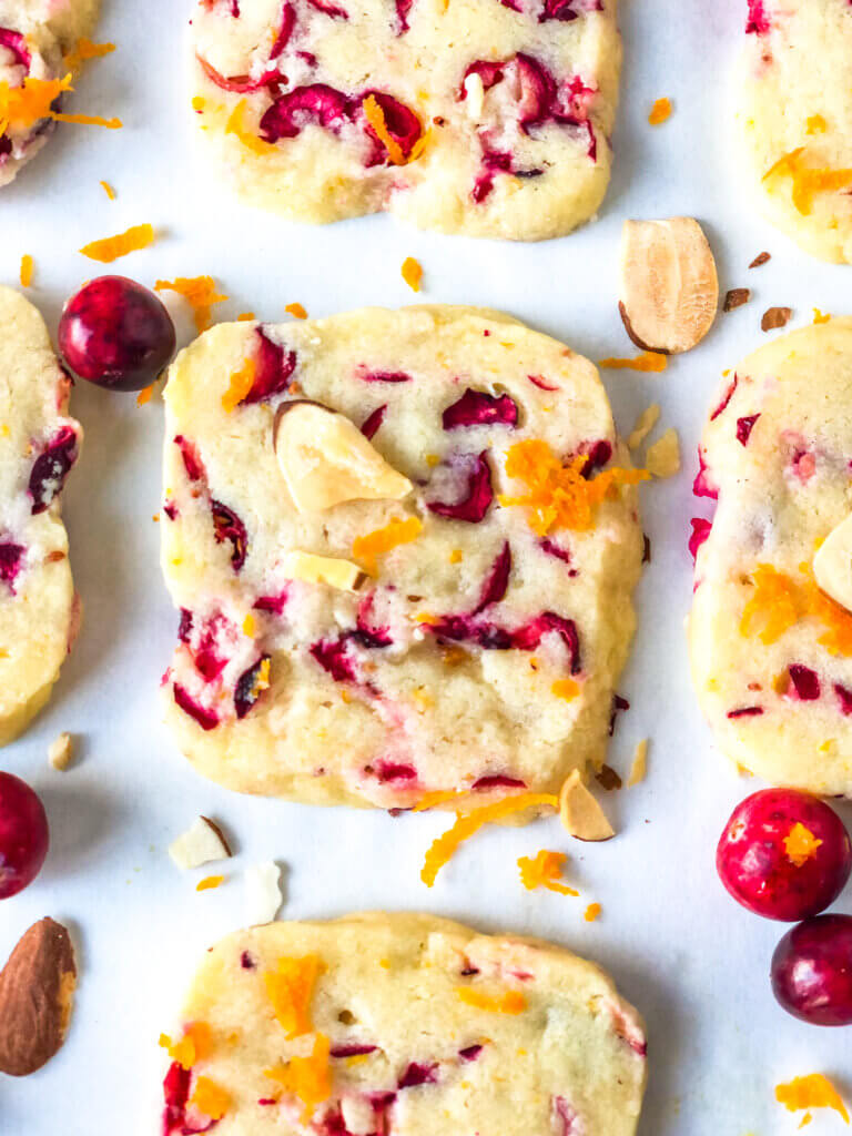 Blog photo showing Overhead close-up of Almond Shortbread cookie with pieces of fresh cranberry and orange zest