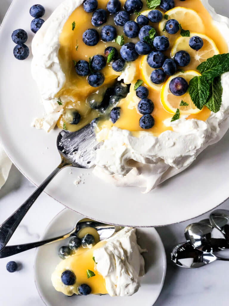 Lemon curd pavlova with slice removed. Slice is shown from above also.