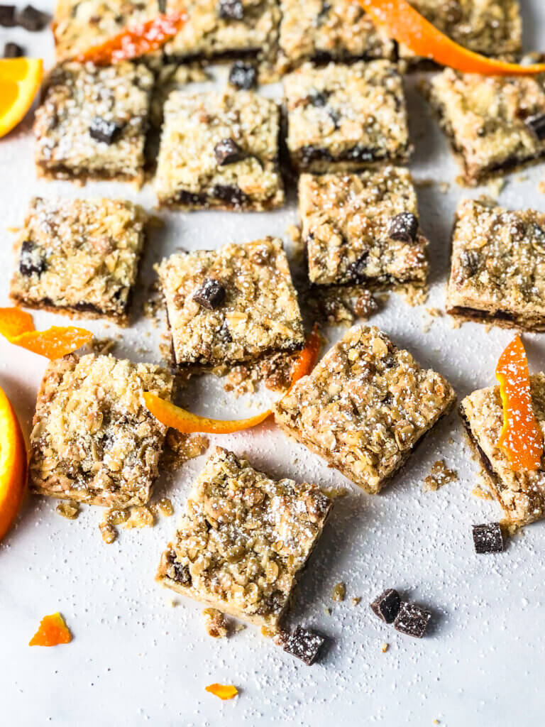 Oat Jam Bars with Chocolate scattered about with chocolate pieces and orange rind