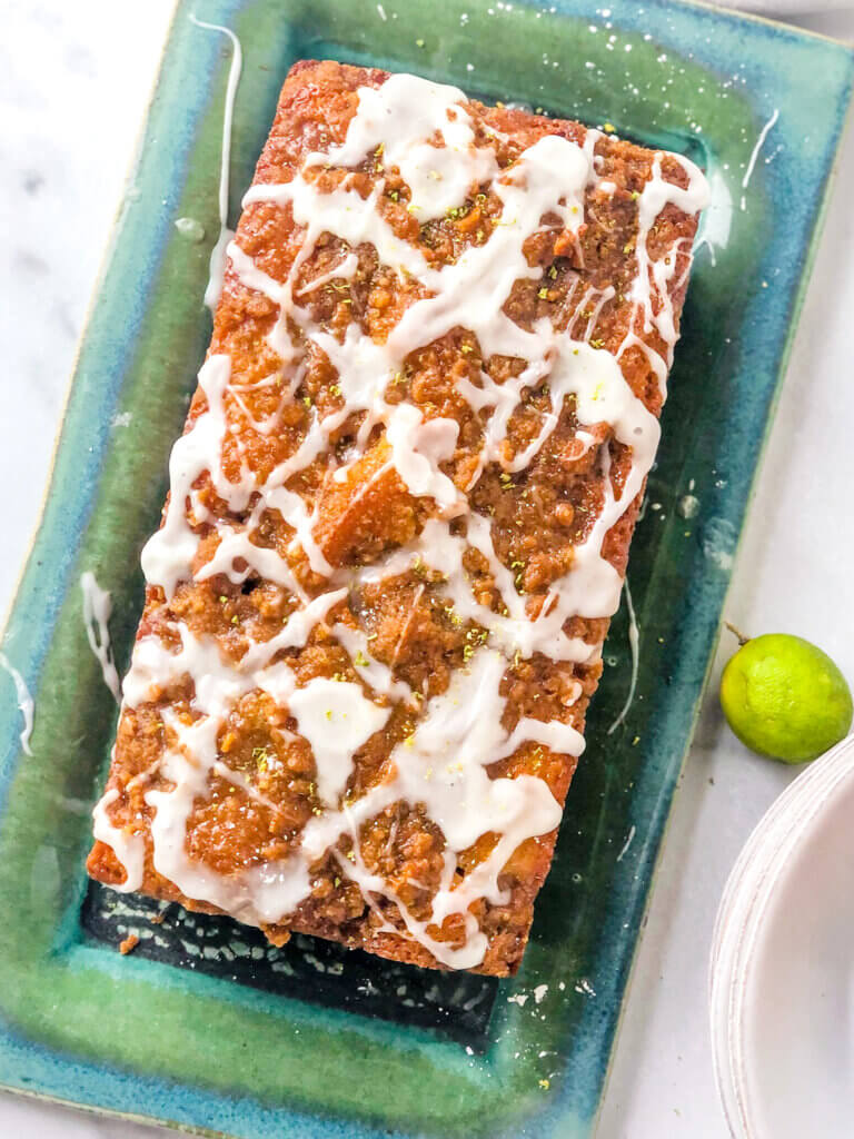 Shows overhead view of craggy golden cake, with splashes of lime glaze.