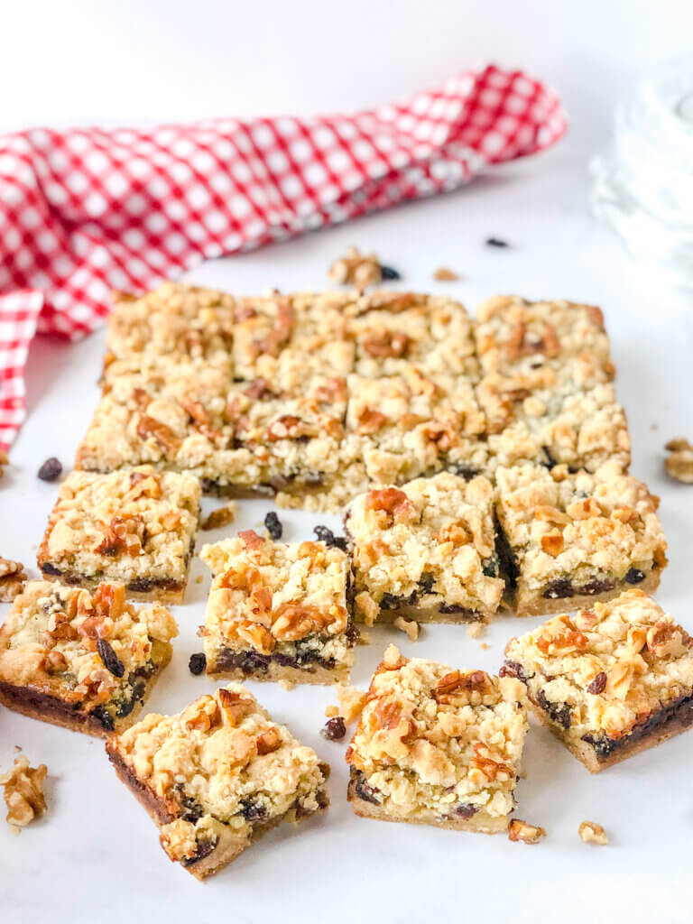 8x8 pan of sliced sour cream raisin bar cookies with layers of crust, raisin-filled custard and crumbly topping with toasted walnuts