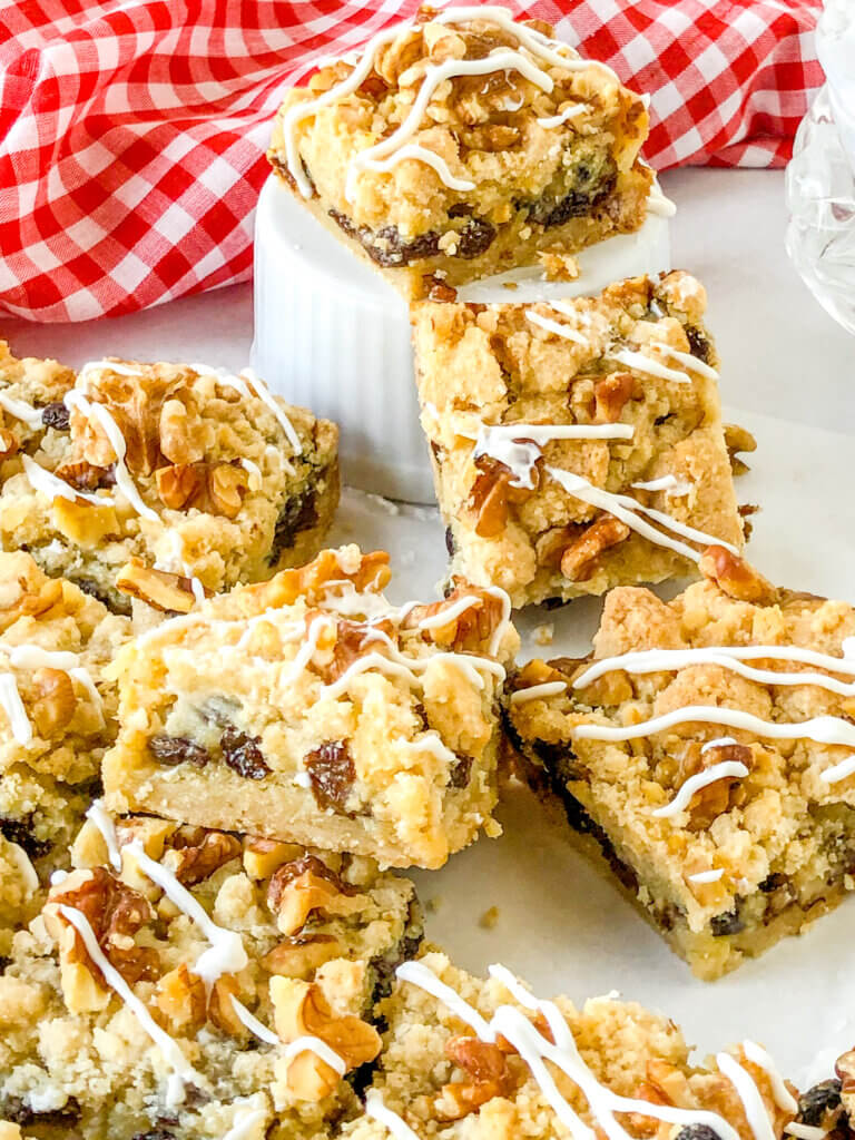 Sour cream raisin bars with layers of crisp shortbread like crust, sour cream raisin custard filling and crumb topping with toasted walnuts